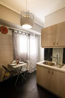 a kitchen with a table and a sink and a table and a window at Bright small penthouse in the center of athens in Athens