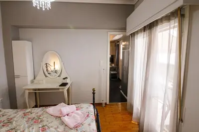 a bedroom with a bed with a mirror and a table at Bright small penthouse in the center of athens in Athens
