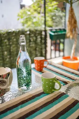 a glass bottle and a cup on a table at Bright small penthouse in the center of athens in Athens