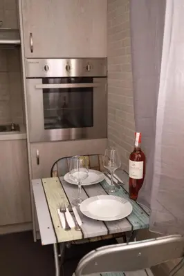 a table with two glasses and a bottle of wine at Bright small penthouse in the center of athens in Athens
