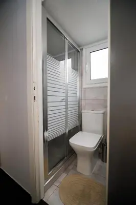 a bathroom with a toilet and a glass shower at Bright small penthouse in the center of athens in Athens