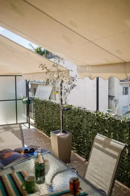 a table and chairs and an umbrella on a balcony at Bright small penthouse in the center of athens in Athens