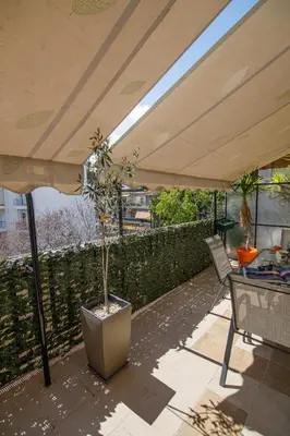 a patio with an umbrella and a potted plant at Bright small penthouse in the center of athens in Athens