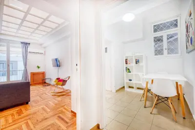 a white living room with a table and chairs at Syntagma Apartment in Athens
