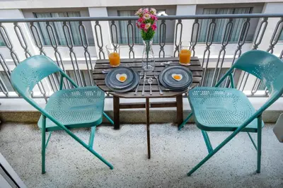 a table and chairs on a balcony with orange juice at Syntagma Apartment in Athens