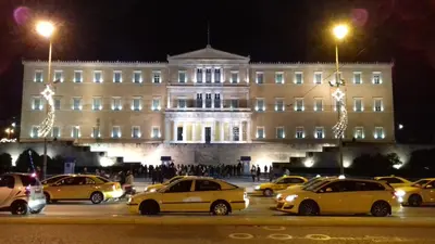 a group of cars parked in a parking lot in front of a building at Syntagma Apartment in Athens