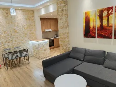 a living room with a couch and a kitchen at Luxury stay near the Acropolis 10-min walk to history! in Athens