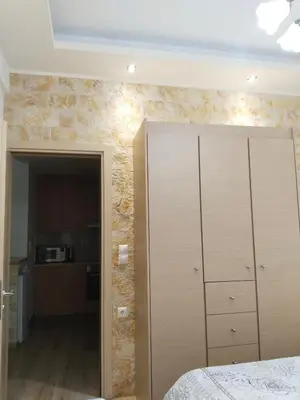 a bedroom with a large cabinet and a kitchen at Luxury stay near the Acropolis 10-min walk to history! in Athens