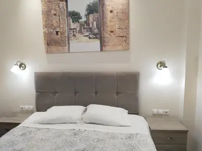 a bed with two pillows and two pictures on the wall at Luxury stay near the Acropolis 10-min walk to history! in Athens