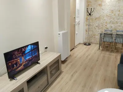 a living room with a flat screen tv on a table at Luxury stay near the Acropolis 10-min walk to history! in Athens