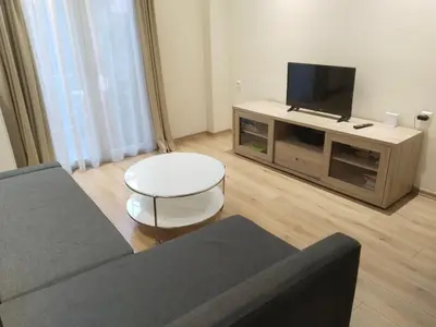 a living room with a couch and a flat screen tv at Luxury stay near the Acropolis 10-min walk to history! in Athens