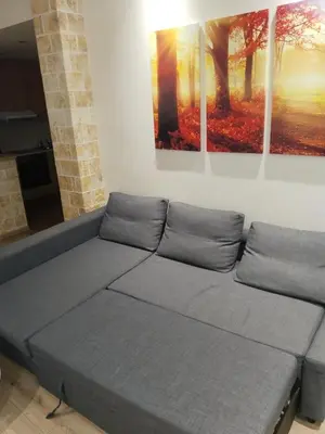 a couch in a room with three paintings on the wall at Luxury stay near the Acropolis 10-min walk to history! in Athens