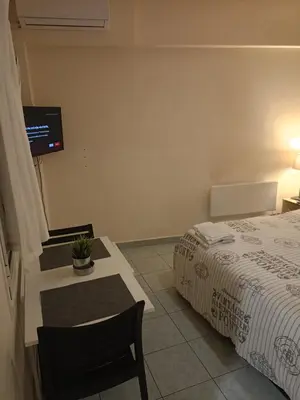 a bedroom with a bed and a table and a tv at Athens Downtown Apartment in Athens