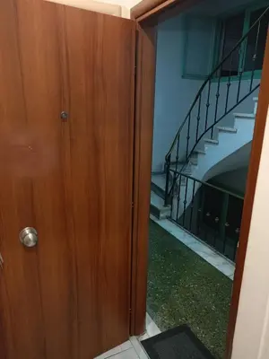 a wooden door leading into a building with a staircase at Athens Downtown Apartment in Athens
