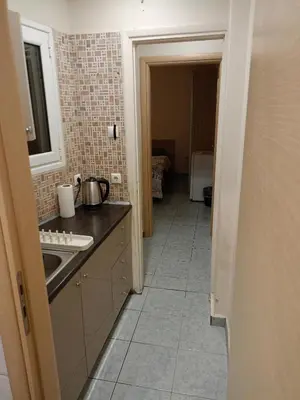 a kitchen with a sink and a tile floor at Athens Downtown Apartment in Athens