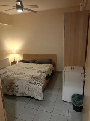 a bedroom with a bed and a refrigerator at Athens Downtown Apartment in Athens
