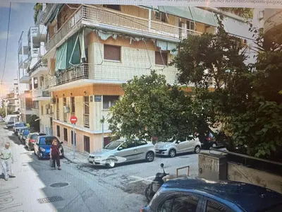 a city street with cars parked in front of a building at Artemis in Athens