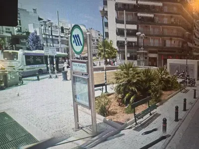 a sign on a city street with a bus at Artemis in Athens