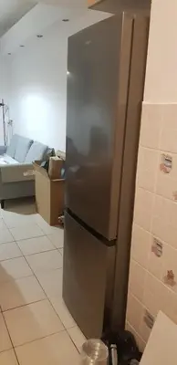 a stainless steel refrigerator in a kitchen with a couch at Artemis in Athens