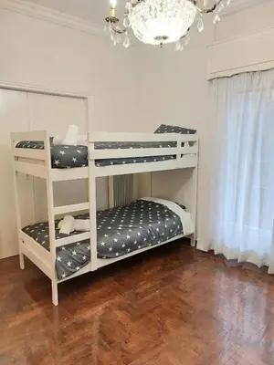 two bunk beds in a room with a chandelier at Dormitory Bunk bed 5' from metro in Athens