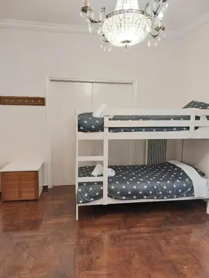 two bunk beds in a room with a chandelier at Dormitory Bunk bed 5' from metro in Athens