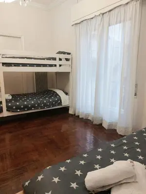 a bedroom with two bunk beds and a wooden floor at Dormitory Bunk bed 5' from metro in Athens
