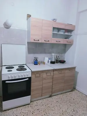 a kitchen with a white stove and wooden cabinets at Dormitory Bunk bed 5' from metro in Athens