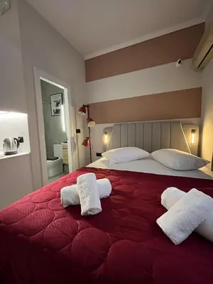 a bedroom with a red bed with two towels on it at Iris suite Stadiou by Zeussuites in Athens