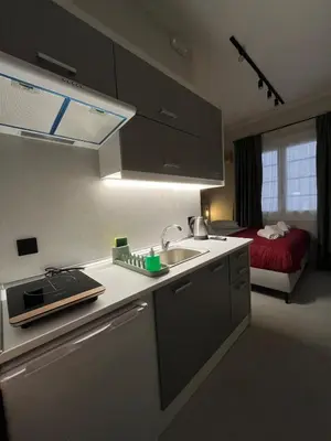 a kitchen with a sink and a bed in a room at Iris suite Stadiou by Zeussuites in Athens