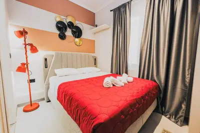 a bedroom with a red bed with two towels on it at Iris suite Stadiou by Zeussuites in Athens