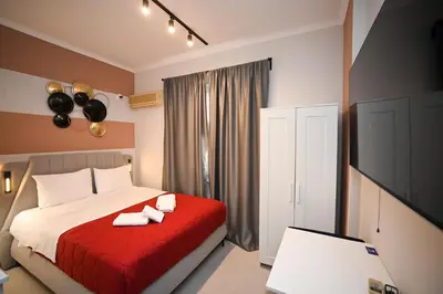 a bedroom with a bed with a red blanket at Iris suite Stadiou by Zeussuites in Athens