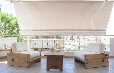 two chairs and a table in front of a large window at Designers apartment in Galatsi area in Athens