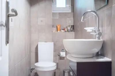 a bathroom with a white toilet and a sink at Designers apartment in Galatsi area in Athens