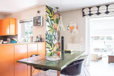 a kitchen with a table and a dining room at Designers apartment in Galatsi area in Athens