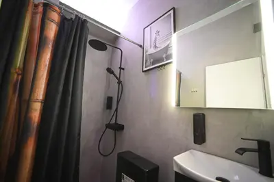 a bathroom with a shower curtain and a sink at Acropolis View Suite Klathmonos by Zeussuites in Athens