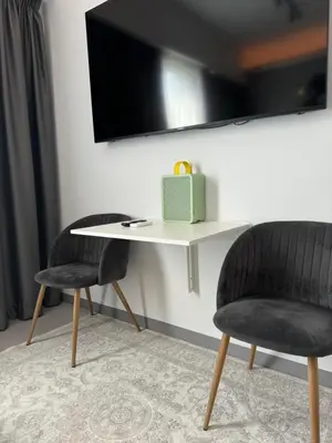 two chairs and a table with a television on a wall at Acropolis Urban Suite Klathmonos by Zeus Suites in Athens