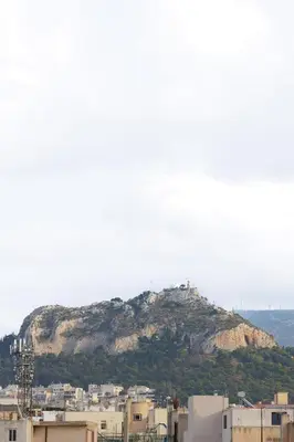 a mountain in the background of a city with buildings at Thea Luxury Rooms Athens in Athens