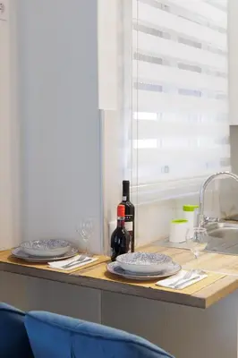 a counter with two plates and wine glasses on it at Thea Luxury Rooms Athens in Athens