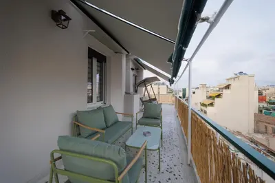 a balcony with chairs and a table on a building at Thea Luxury Rooms Athens in Athens