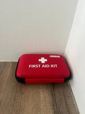 a red first aid kit sitting on the floor at Thea Luxury Rooms Athens in Athens