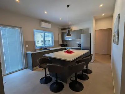 a kitchen with a table with chairs and a refrigerator at Spacious seaside flat at alimos in Athens