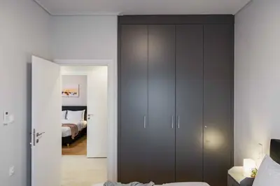 a bedroom with gray cabinets and a bed at Spacious seaside flat at alimos in Athens