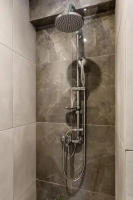 a shower with a shower head in a bathroom at Spacious and sunlit seaside flat in Athens