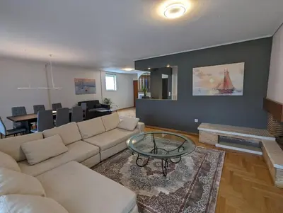 a living room with a couch and a table at Spacious and sunlit seaside flat in Athens