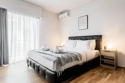 a bedroom with a large bed and a large window at Spacious and sunlit seaside flat in Athens