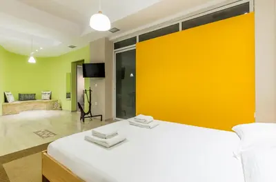 a bedroom with a large bed with a yellow wall at Comfort Kolonaki Stay - Piano & Art in Athens