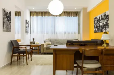 a living room with a couch and a table and chairs at Comfort Kolonaki Stay - Piano & Art in Athens