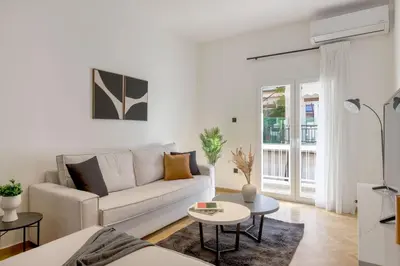 a white living room with a couch and a table at Adorable 2BR Apartment in Neos Kosmos by UPSTREET in Athens