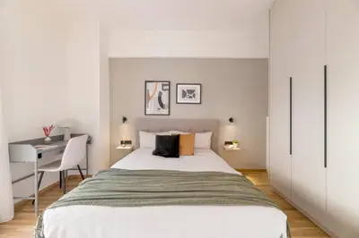 a white bedroom with a bed and a desk at Adorable 2BR Apartment in Neos Kosmos by UPSTREET in Athens