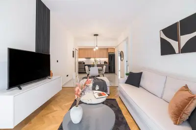 a living room with a white couch and a tv at Adorable 2BR Apartment in Neos Kosmos by UPSTREET in Athens